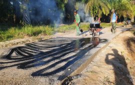 Satgas TMMD Kodim Bengkalis Bersama Warga Penyiraman Aspal Jalan Sekolah Dusun lll